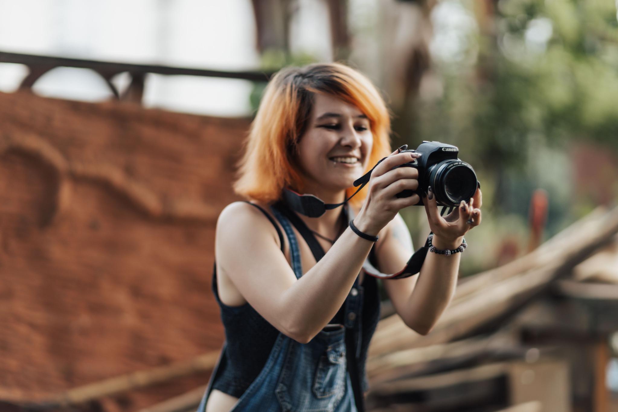 A woman smiling as she photographs a place she is exploring